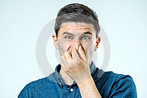 Man holding his nose against a bad smell