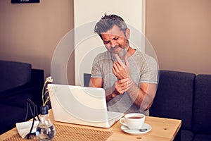 Man holding his wrist pain from using computer. Office syndrome hand pain by occupational disease