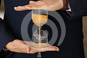 Man holding hourglass, closeup. Time management concept