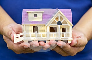 Man holding house model in his hand. The concept of constructing