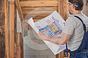 Man holding a house plan in his hands