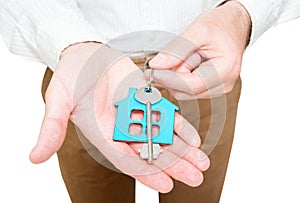 Man holding a house shaped keychain with a key