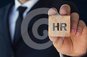 Man holding HR word on wooden cube photo