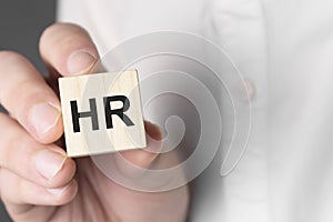 Man holding HR word on wooden cube