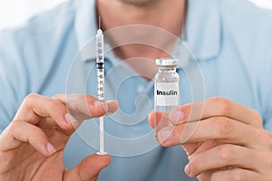 Man Holding Insulin And Syringe