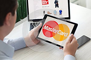 Man holding iPad Pro payment system service MasterCard on screen