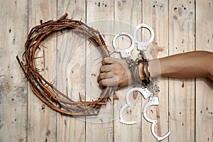 Man Holding Jesus Crown Thorns with His Hand and Many Handcuffs.