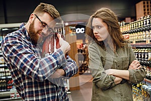 Man holding keg of beer with displeased woman