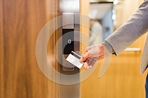 Man holding key card on sensor to open elevator door in modern building or hotel