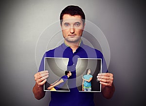 Man holding the lacerated photo of young couple