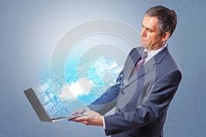 Man holding laptop with cloud based system notifications