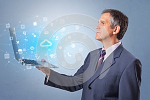 Man holding laptop with cloud based system notifications