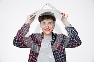 Man holding laptop on his head like roof of hous photo