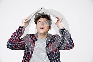 Man holding laptop on his head like roof of hous photo