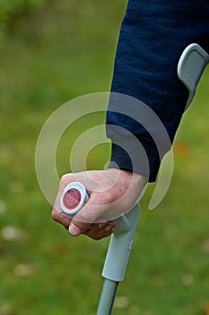 A man holding and leaning his crutch