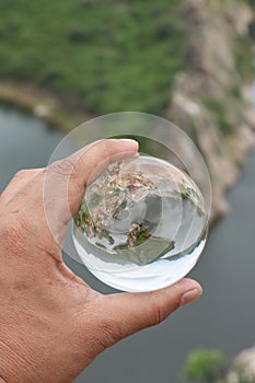 A man holding lensball in his hand with a reflection