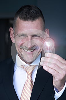 Man holding a lightbulb and smiles