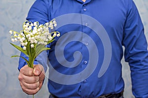 Man holding lilies of valley. Gift on March 8