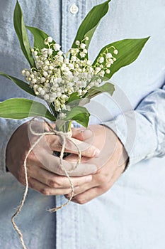 Man holding lily of valley flower bouquet