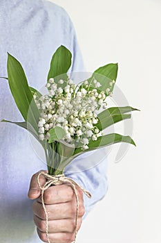 Man holding lily of valley flower bouquet