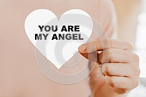 Man holding a love card in the shape of a heart with You are my angel