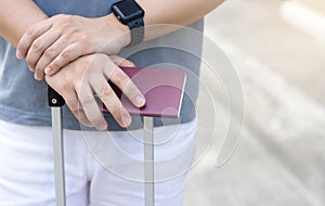 Man holding luggage with passport on blurred city background for activity lifestyle outdoors freedom or travel tourism