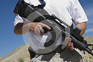 Man Holding Machine Gun At Firing Range