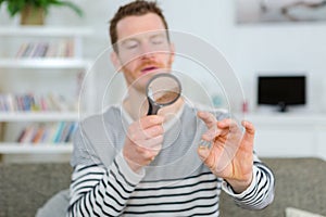 man holding magnifying glass and magnifying viewer ring