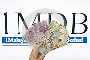 Man holding Malaysia Ringgit with burr 1MDB background indicating the US Government inves