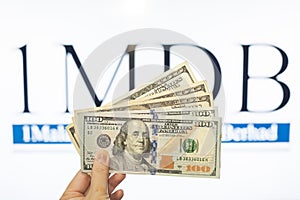 Man holding Malaysia Ringgit with burr 1MDB background indicating the US Government