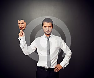 Man holding mask with crying face