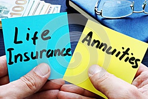 Man holding memo sticks. Life Insurance vs. Annuities.