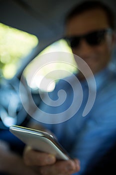Man holding mobile phone in car