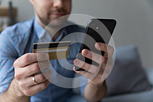 Man holding mobile phone and credit card, using ecommerce app