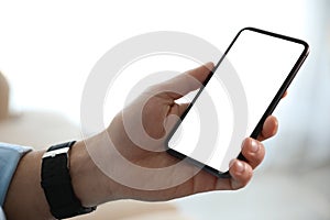 Man holding mobile phone with empty screen, closeup