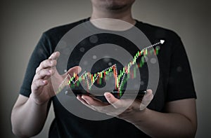 Man holding mobile phone and showing hologram stock market trade exchange graph. Planning and strategy, investment, business