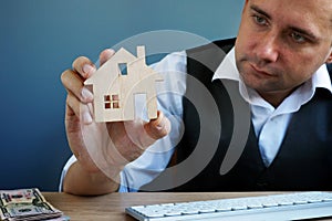 Man holding model of home. Property investment and house mortgage