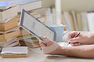 Man holding a modern ebook reader and book in library