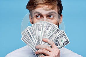 man holding money close-up wealth success blue background