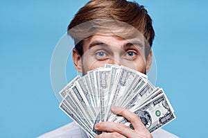 man holding money close-up wealth success blue background