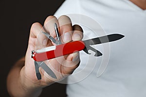 Man holding multitool on dark background, closeup