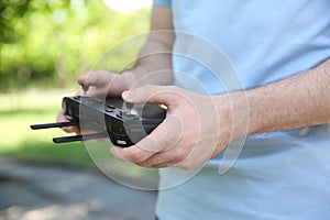 Man holding new drone controller outdoors, closeup of hands