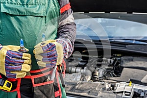 Man holding new lamps near car headlamps