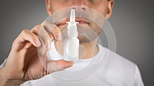 Man holding nose nasal spray medicine