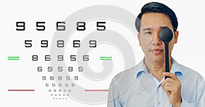 Man holding ocluder with eye vision examination chart