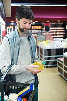 Man holding oil bottle shopping basket