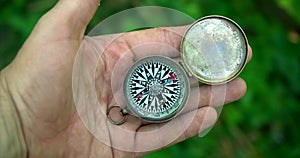 Man holding an old compass in hand and rotate around the axis