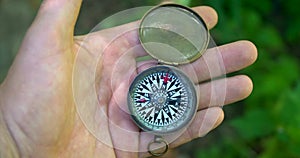 Man holding an old compass in hand and rotate around the axis.