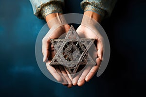 A man holding an old and rusty star of David in their hands on ruins background.