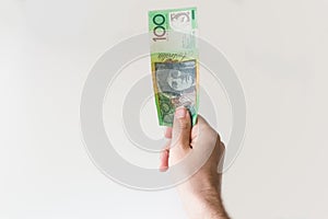 Man holding one hundred Australian Dollar note in his hand